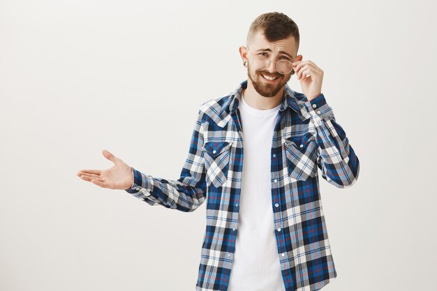 Un uomo dall'aria indifferente, che si fa beffe di cose stupide, si mette gli occhiali