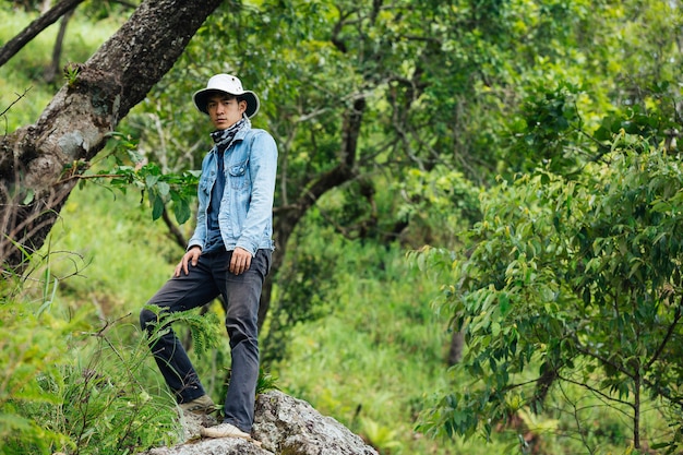 Un uomo di escursionismo felice cammina attraverso la foresta con uno zaino.