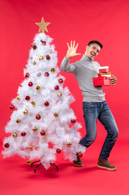 Un uomo è in piedi vicino all'albero di Natale