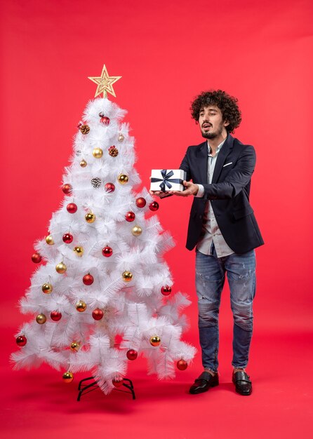 Un uomo è in piedi vicino all'albero di Natale