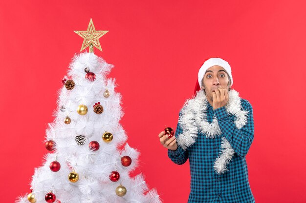 Un uomo è in piedi vicino all'albero di Natale