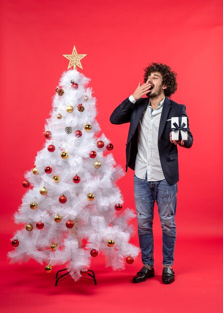 Un uomo è in piedi vicino all'albero di Natale