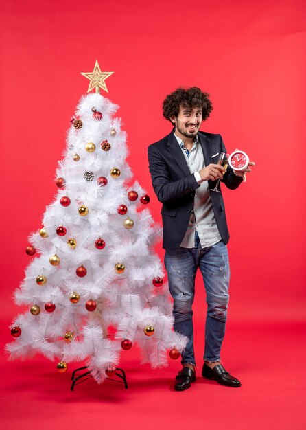 Un uomo è in piedi vicino all'albero di Natale