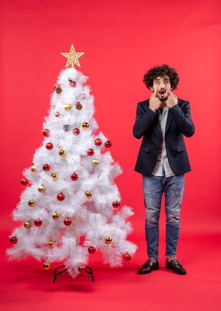 Un uomo è in piedi vicino all'albero di Natale