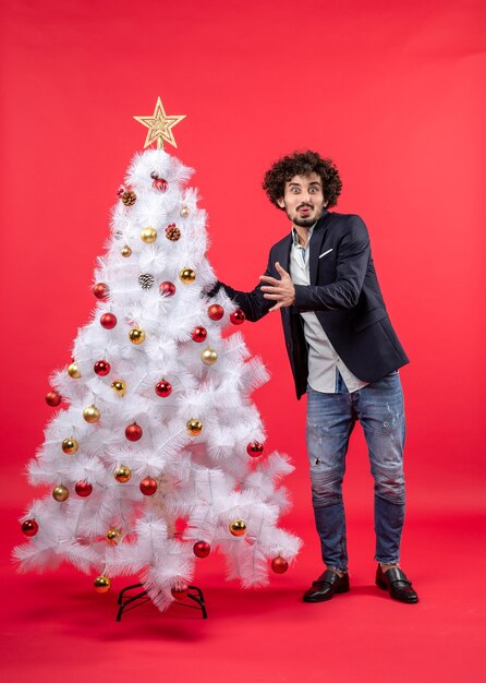 Un uomo è in piedi vicino all'albero di Natale