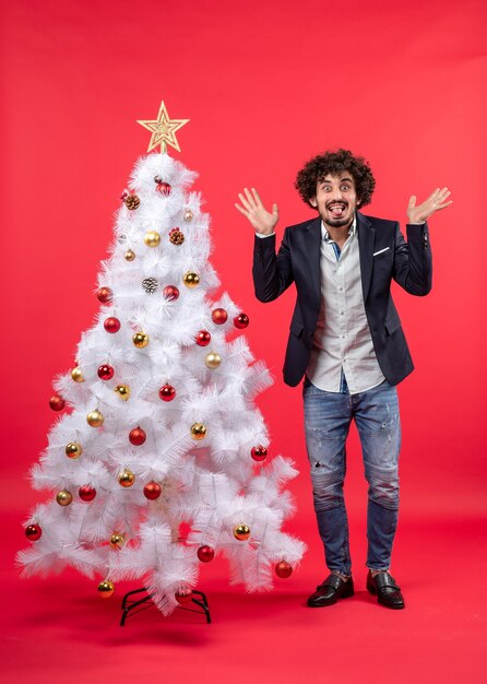 Un uomo è in piedi vicino all'albero di Natale