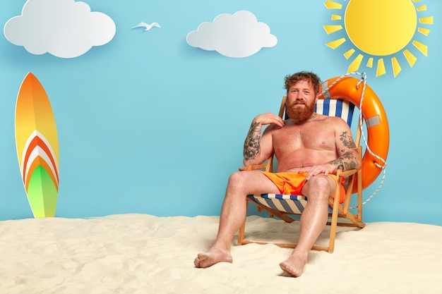 Un uomo insoddisfatto di Foxy si scotta dal sole in spiaggia, ha la pelle rossa, si siede su una sedia a sdraio mezzo nudo