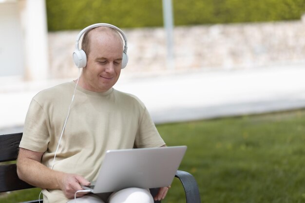 un uomo lavora su un laptop nel parco