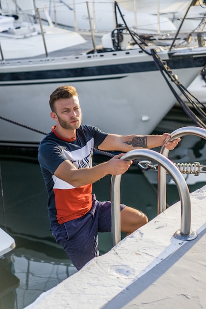 un uomo nel porto che prepara lo yacht per il viaggio