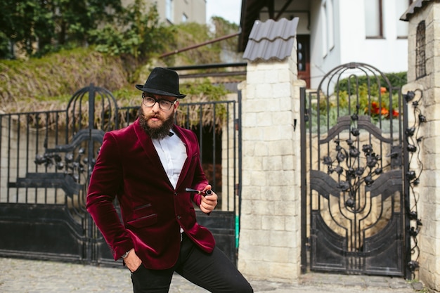 Un uomo ricco con la barba fuma la culla