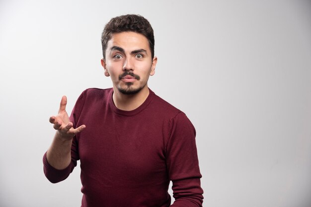 Un uomo serio del brunette in piedi e in posa