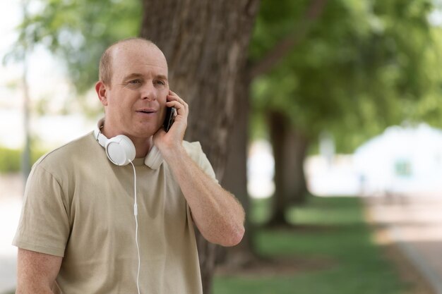 Un uomo sta parlando su uno smartphone nel parco