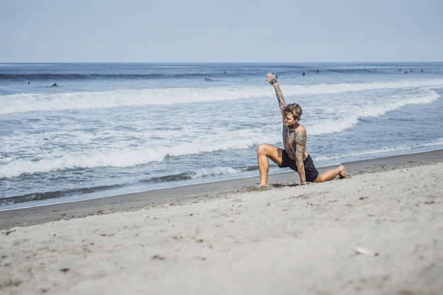 un uomo sulla costa oceanica è impegnato nello sport, facendo ginnastica