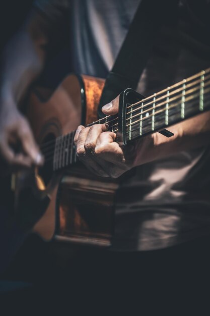 Un uomo suona un primo piano di chitarra acustica