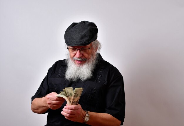 Un vecchio con la barba che conta i suoi soldi