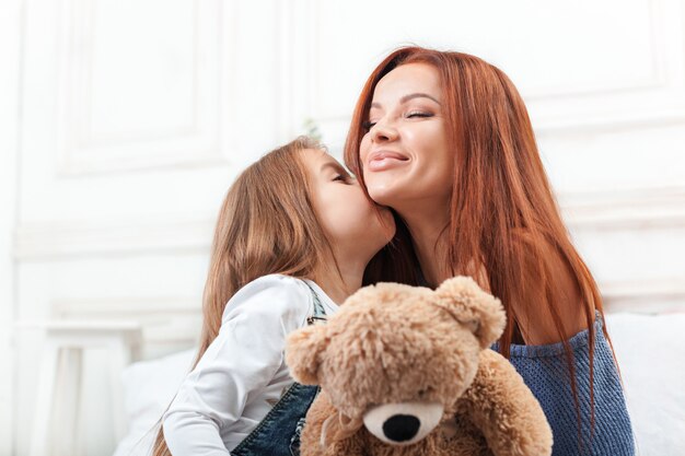 Una bambina carina godendo, giocando e creando con il giocattolo con la madre