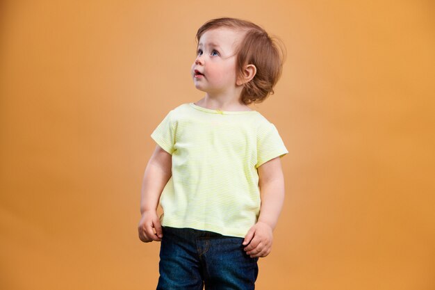 Una bambina carina su sfondo arancione
