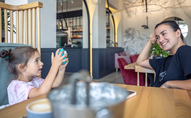 Una bambina scatta una foto di sua madre su una macchina fotografica per la stampa di foto istantanea.