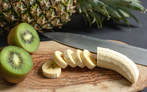 Una banana e un ananas vengono messi su un tagliere uno accanto all'altro
