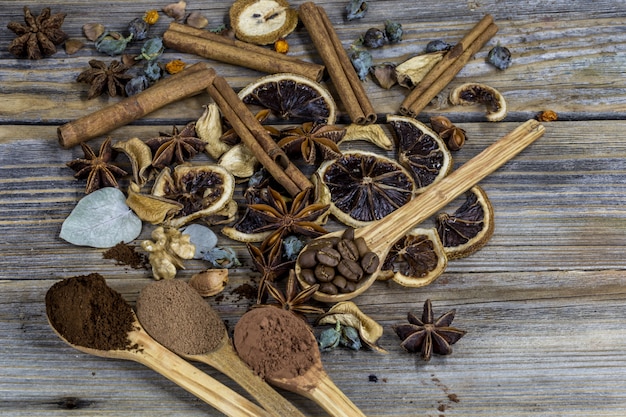 Una bella disposizione di limoni essiccati, cannella, caffè su cucchiai di legno su legno