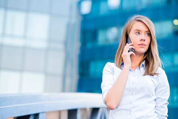 Una bella donna giovane agente immobiliare al telefono