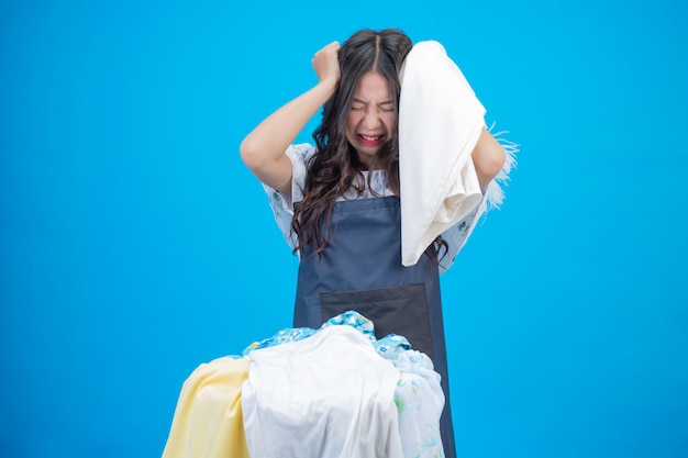 Una bella donna in possesso di un panno preparato per lavare sul blu