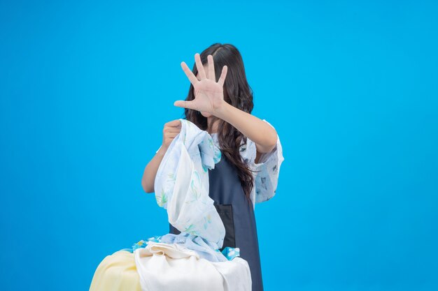 Una bella donna in possesso di un panno preparato per lavare sul blu