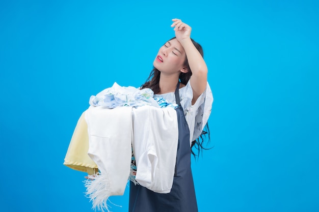 Una bella donna in possesso di un panno preparato per lavare sul blu