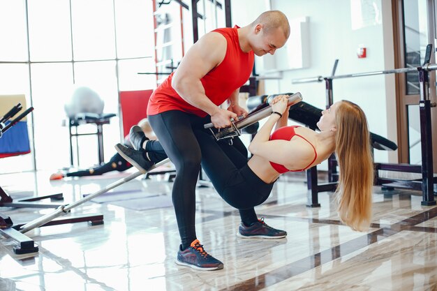 Una bella e atletica ragazza sportiva che si allena in palestra con un amico