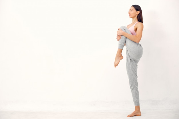 Una bella ragazza è impegnata in uno studio di yoga