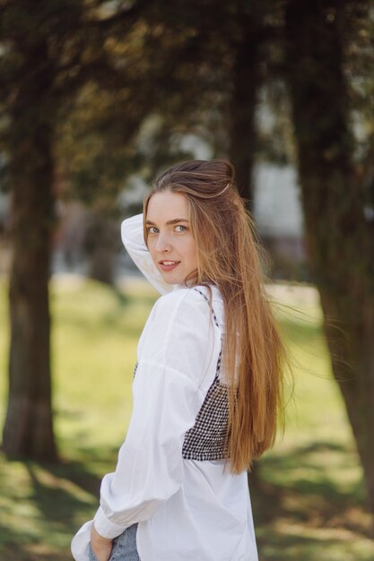 Una bella ragazza va in giro per la città sorridendo e posando