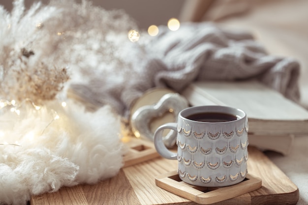 Una bella tazza con una bevanda calda sullo spazio delle cose accoglienti. Comfort domestico e concetto di calore.