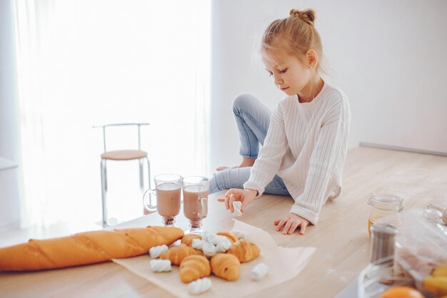 una bellissima gitl giovane con capelli chiari in pizzo bianco e pantaloni blu jeans seduti a casa