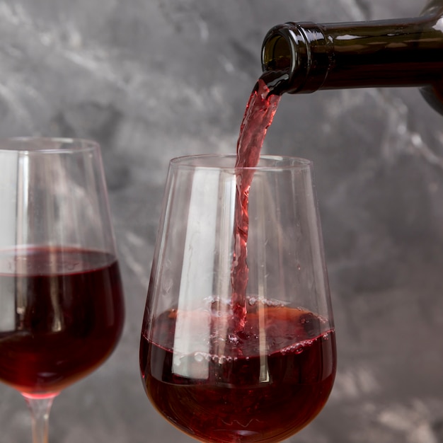 Una bottiglia di vino che riempie wineglass