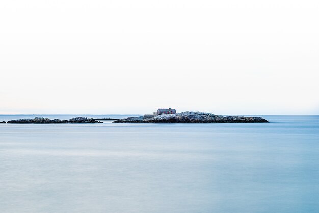 Una casa costruita su una piccola isola rocciosa in mezzo al mare