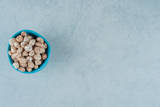 Una ciotola blu piena di pan di zenzero dolce e delizioso sulla superficie bianca white