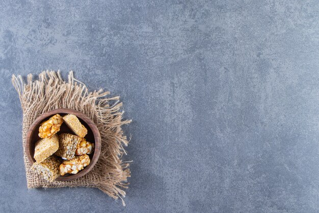 Una ciotola di barrette di muesli in una trama, sullo sfondo di marmo.