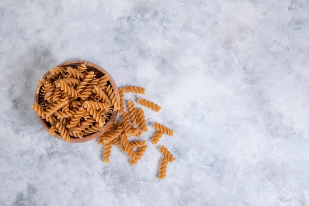 Una ciotola di legno di Fusilli di pasta secca cruda italiana. Foto di alta qualità