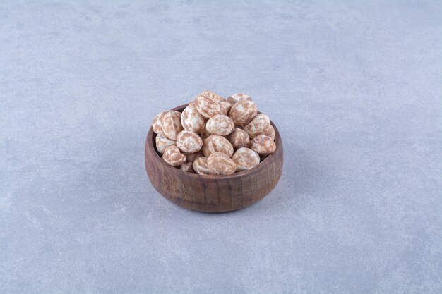 Una ciotola di legno piena di cereali sani su una superficie grigia