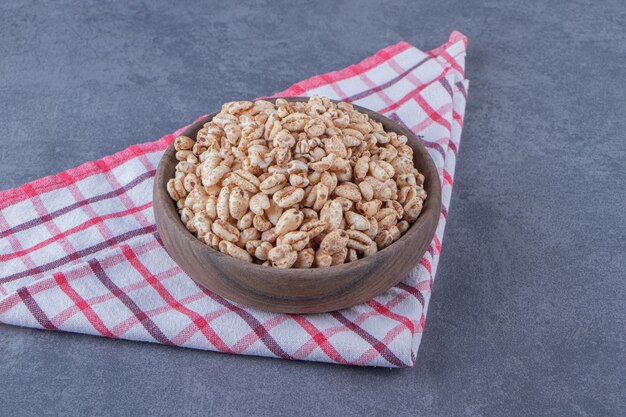 Una ciotola di muesli dolce su un canovaccio, sullo sfondo di marmo. Foto di alta qualità