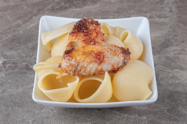 Una ciotola di pasta con bolognese, sulla superficie di marmo.