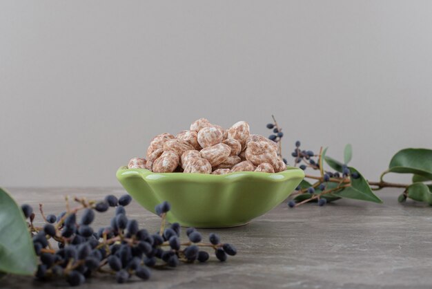 Una ciotola di pasticceria con uva e foglie sulla superficie di marmo