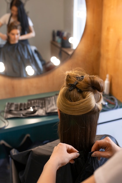 Una cliente si fa fare i capelli dal parrucchiere.