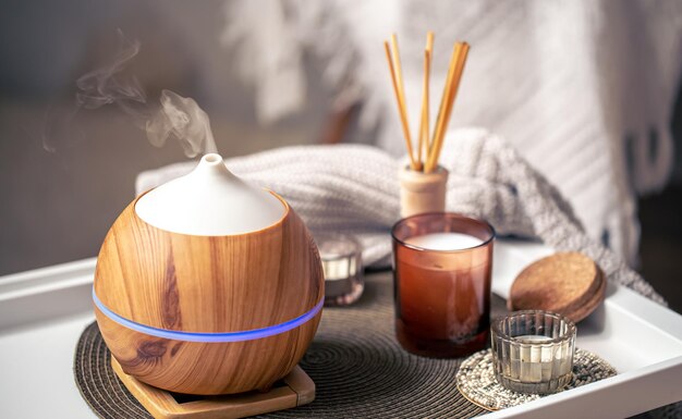 Una composizione accogliente con un diffusore di aromi e candele in un interno di casa