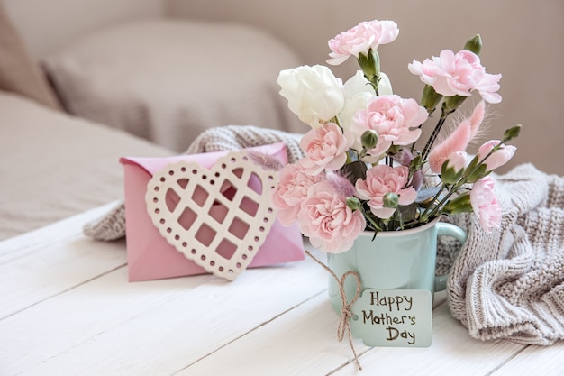 Una composizione festosa con fiori freschi in un vaso, elementi decorativi e un augurio di Buona Pasqua su una cartolina.