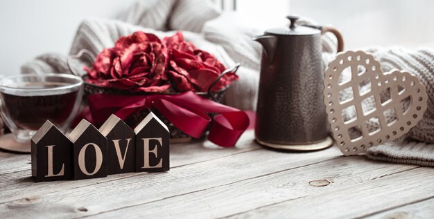 Una composizione romantica per San Valentino con la parola decorativa amore e dettagli d'arredo.