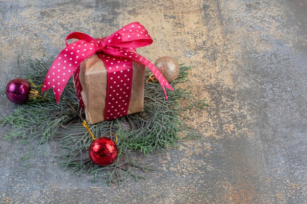 Una confezione regalo in carta con fiocco e palla di Natale. Foto di alta qualità