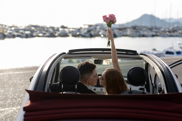 Una coppia appena sposata dentro una piccola macchina