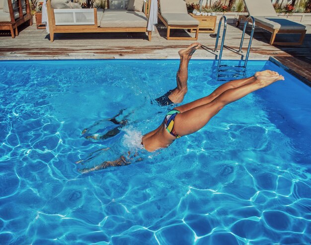 Una coppia attraente, un bel maschio muscoloso e una donna sexy saltano in acqua. Godersi la vacanza.