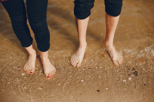 Una coppia elegante e bella in abiti neri passa un buon tempo in spiaggia